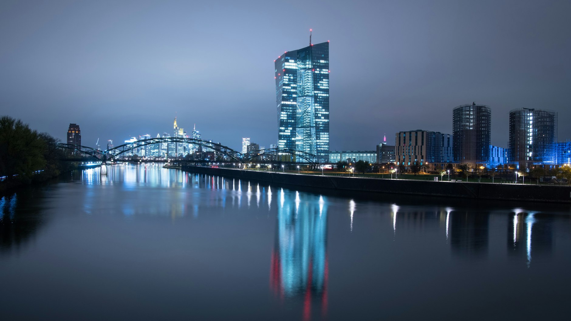 Die Lichter der Bankenskyline von Frankfurt und der EZB leuchten in der Nacht.