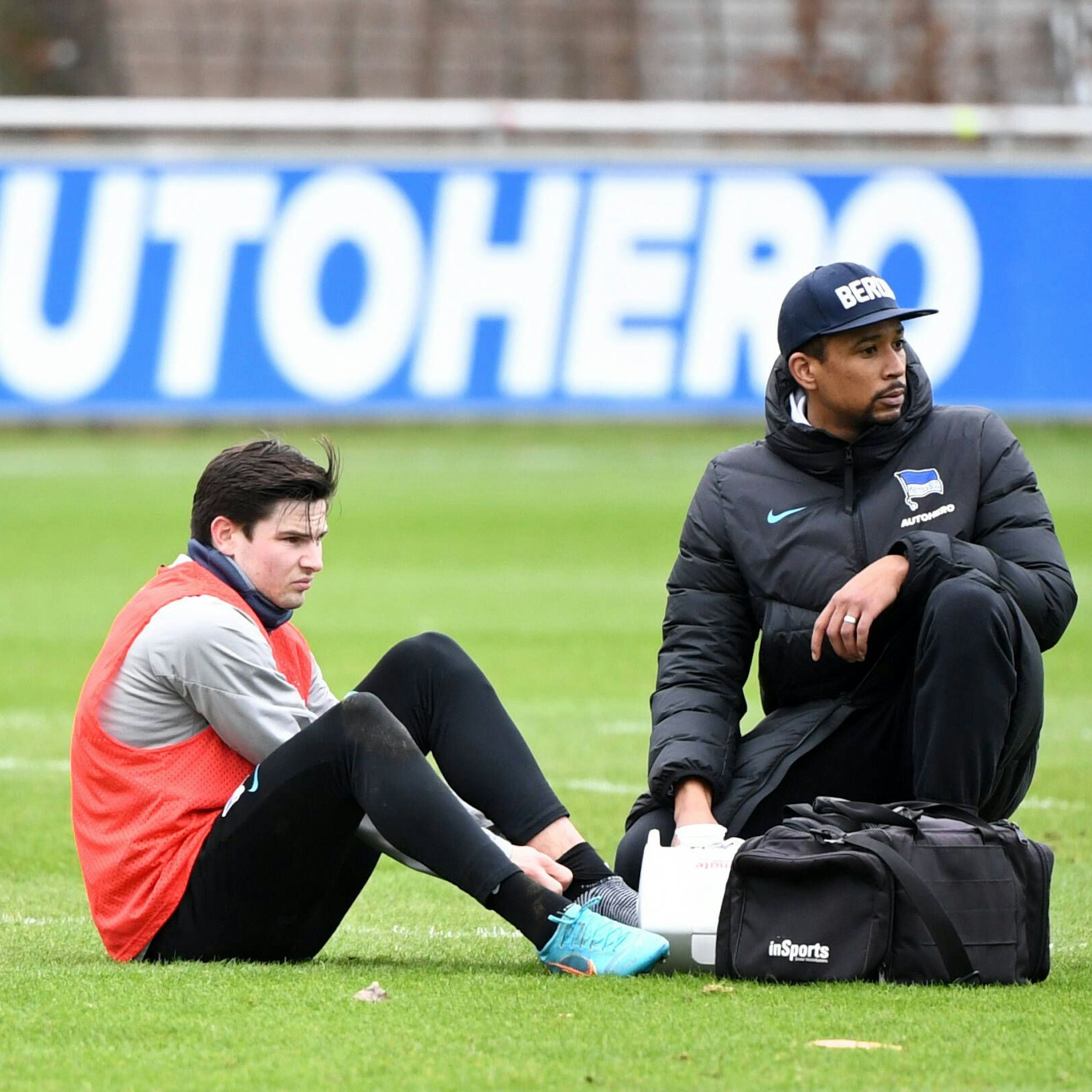 Jurgen Ekkelenkamp hält sich seinen linken Knöchel, wird von Physio Freddy Syna behandelt.