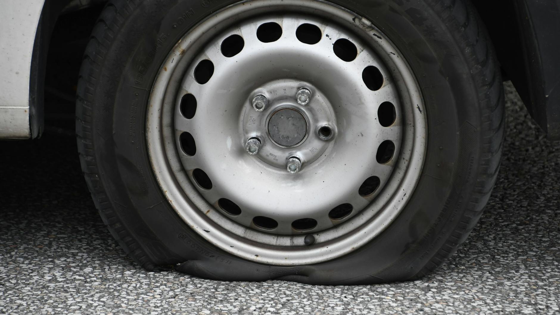 Ein platter Autoreifen (Symbolbild). Unbekannte haben in Berlin an zahlreichen SUV die Luft aus den Reifen gelassen. Die Polizei geht davon aus, dass sich die Täter für Klimaschützer halten.