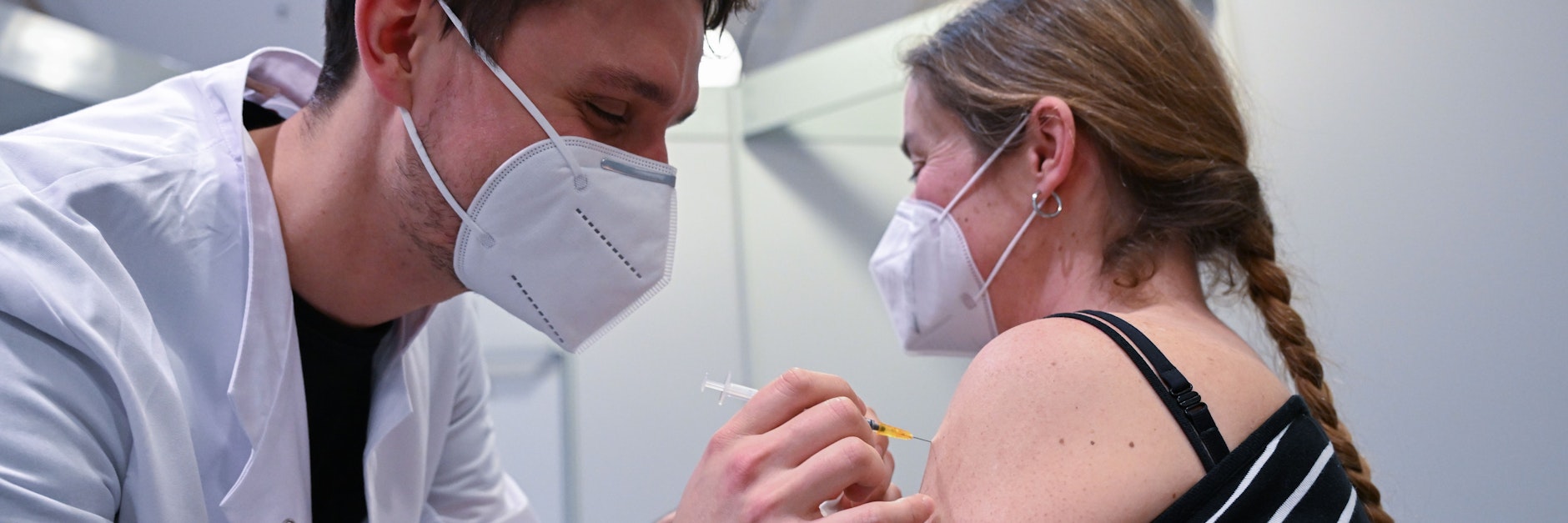 Eine Klinikmitarbeiterin lässt sich in einer Impfstation in Stuttgart gegen Corona impfen.