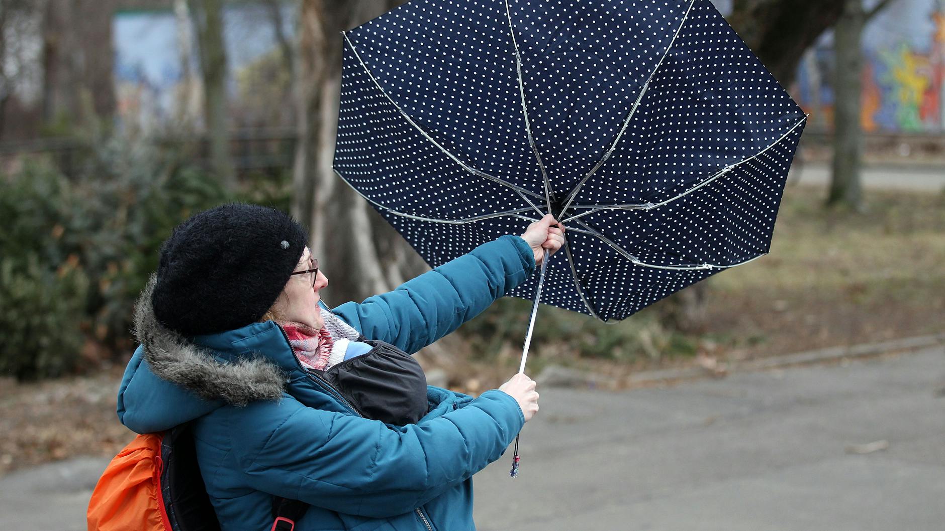 Berlin: Eine Frau mit Regenschirm kämpft gegen den Sturm an (Symbolbild).