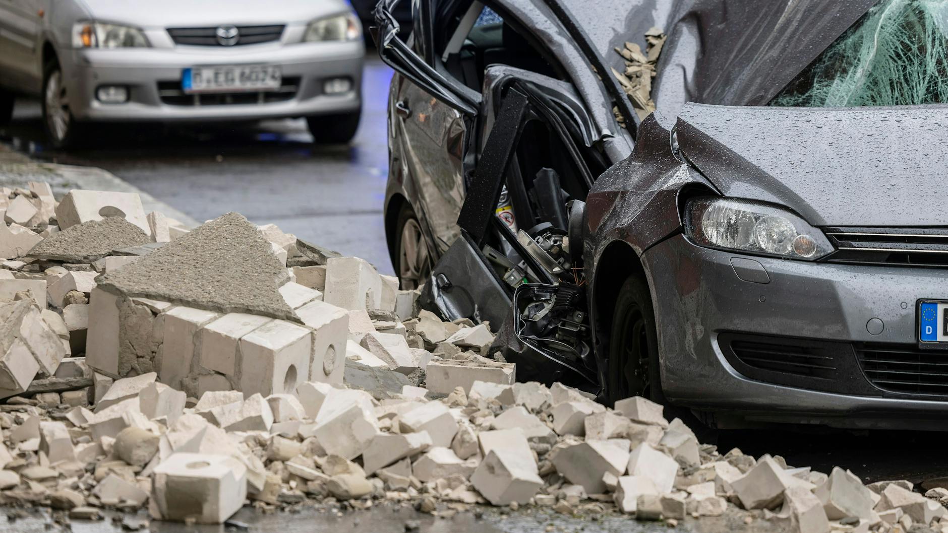 Berlin-Mitte: Trümmer einer Hausfassade sind auf den Gehweg und ein Auto gefallen.
