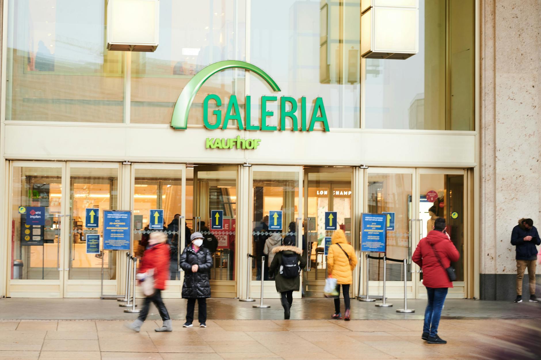 25.01.2022, Berlin: Menschen kommen aus oder gehen in den Galeria Kaufhof am Alexanderplatz. Die Warenhauskette Galeria Karstadt Kaufhof will viele Häuser dicht machen. 