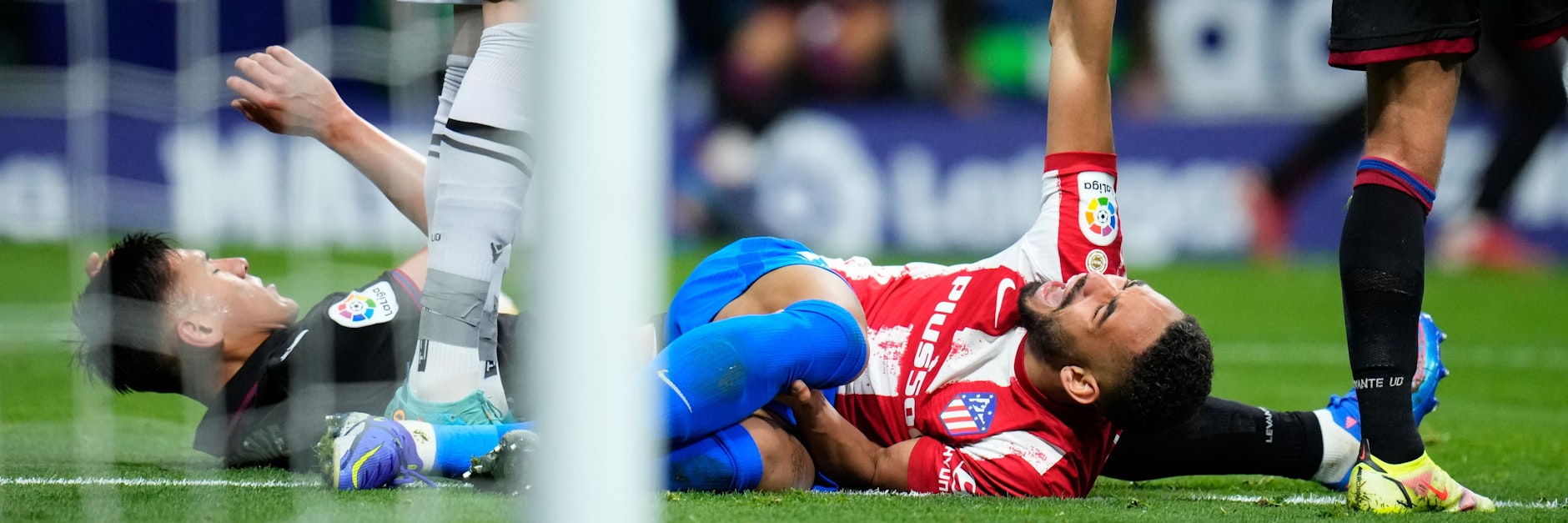Matheus Cunha hält sich nach einem Zusammenprall das Knie und schreit vor Schmerzen.