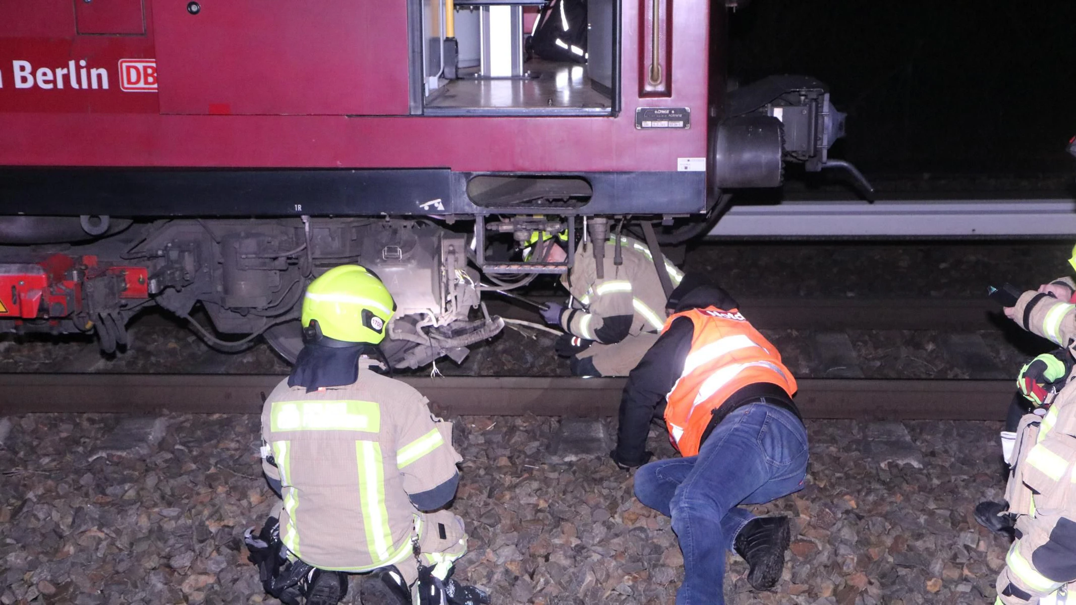 Einsatzkräfte untersuchen die Schäden an der S-Bahn.