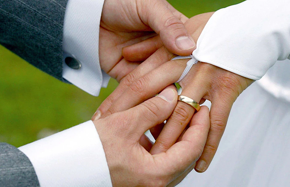 Bei der Trauung streift der Bräutigam der Braut einen Ehering über den Ringfinger.