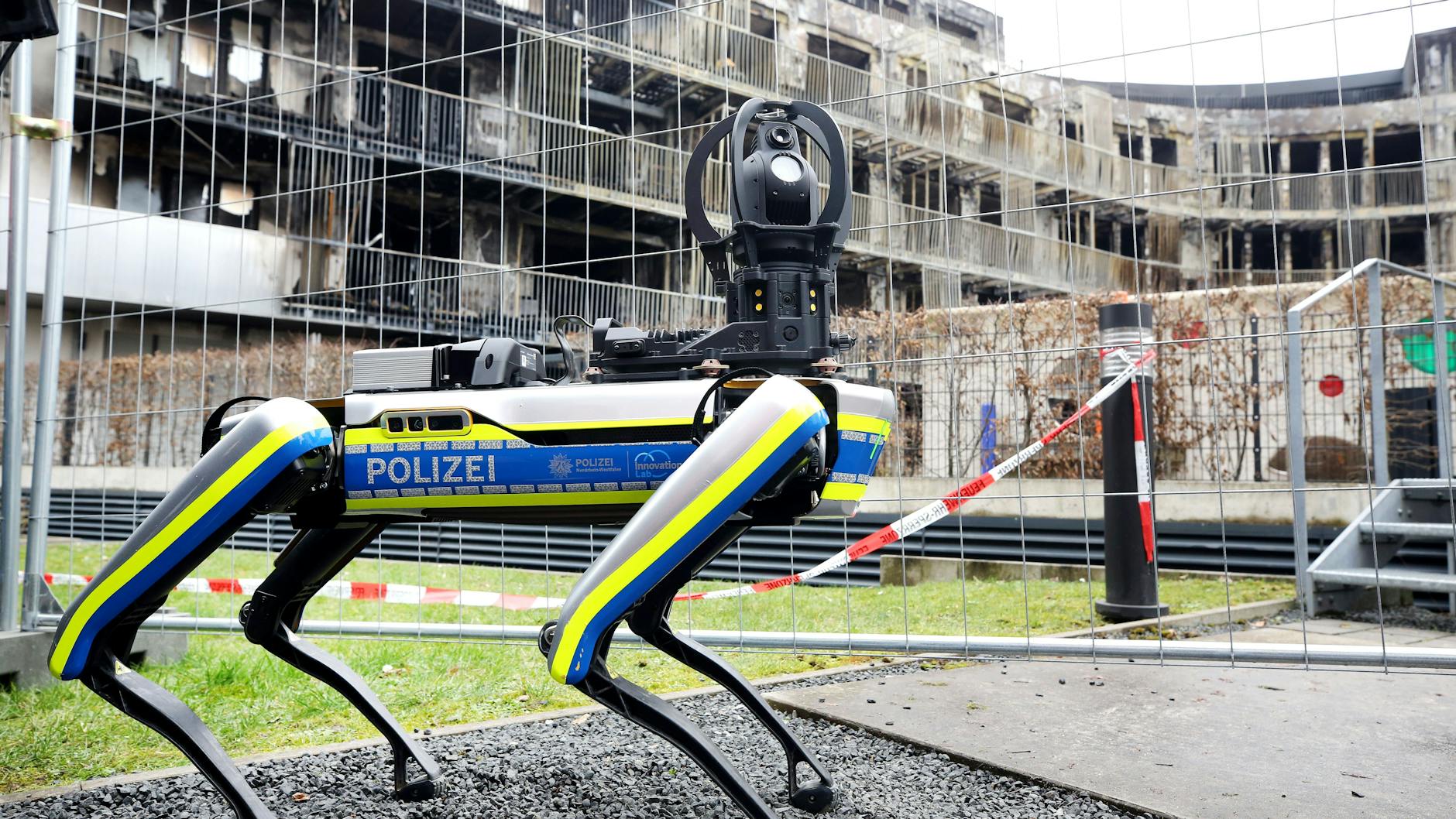 Ein Polizei-Roboter ist am ausgebrannten Wohnkomplex im Einsatz. Mit dem 35 Kilogramm schweren Laufroboter soll das einsturzgefährdete Gebäude nach dem Ende der Löscharbeiten erkundet werden.