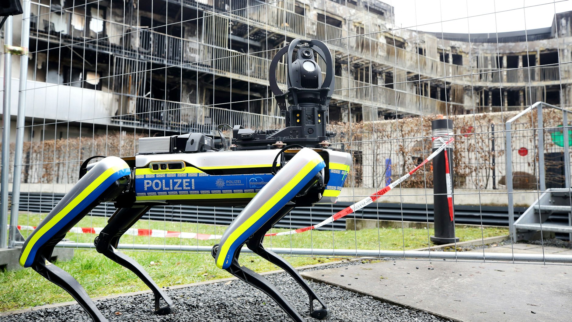 Ein Polizei-Roboter ist am ausgebrannten Wohnkomplex im Einsatz. Mit dem 35 Kilogramm schweren Laufroboter soll das einsturzgefährdete Gebäude nach dem Ende der Löscharbeiten erkundet werden.