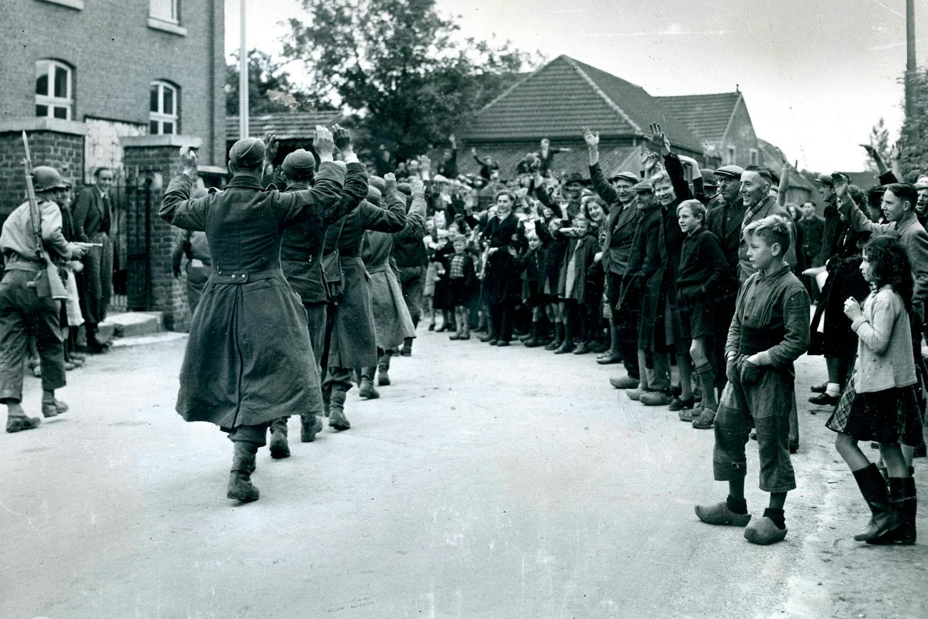 Nach der Befreiung der Niederlande: Deutsche Soldaten werden unter dem Jubel von Anwohnern abgeführt, bewacht durch US-Soldaten.