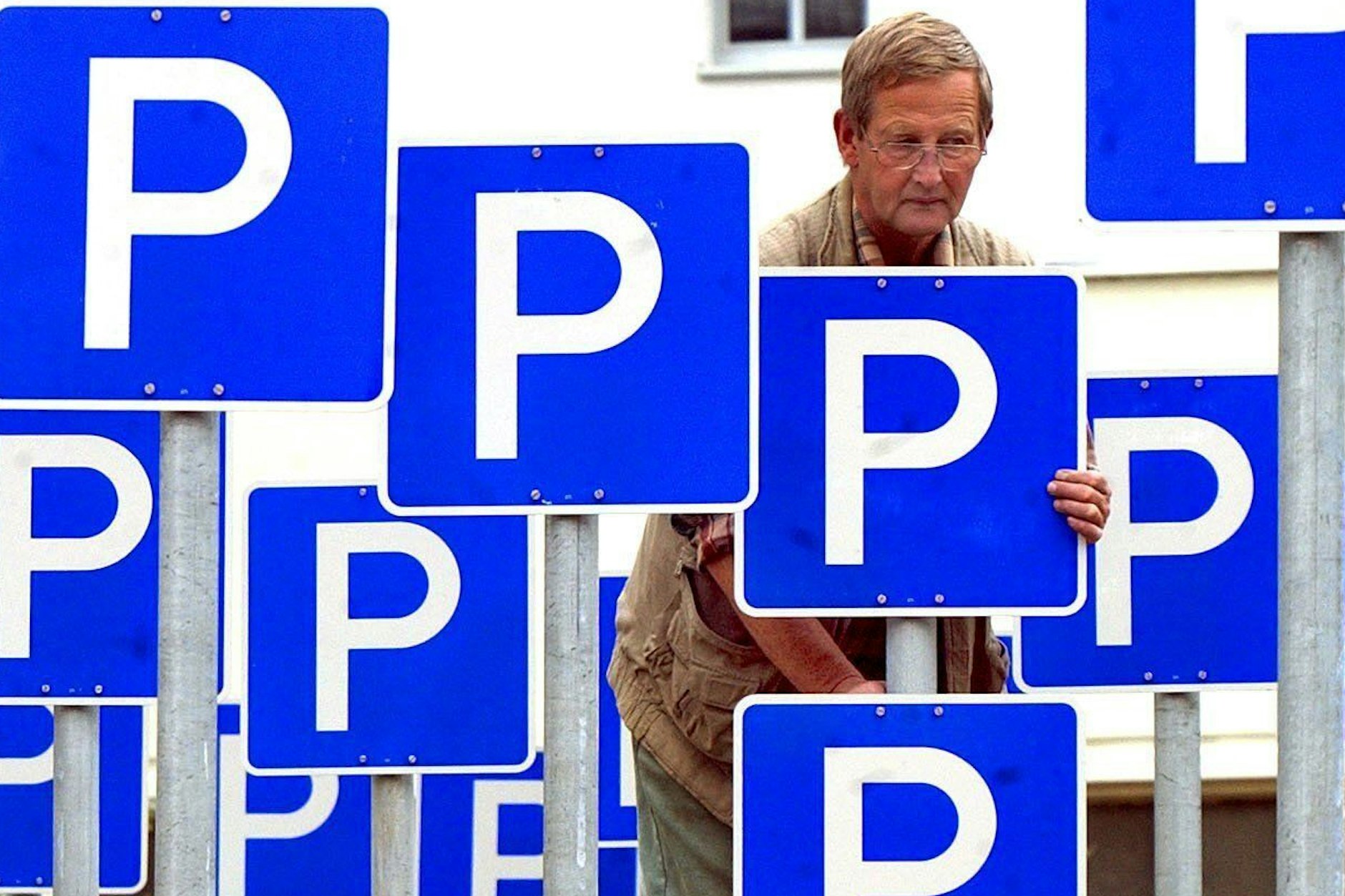 Olaf Buchheim vom Garten- und Landschaftsbau Markranstädt montiert am Lindenauer Markt in Leipzig 100 Parkplatzschilder.