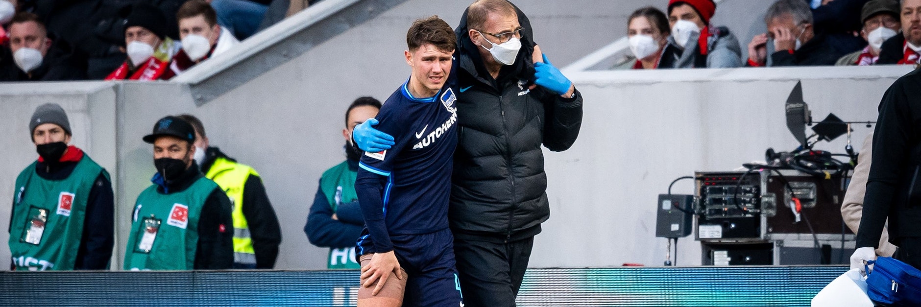 Herthas Linus Gechter hält sich seinen rechten Oberschenkel, während ihn Mannschaftsarzt Dr. Uli Schleicher stützt.