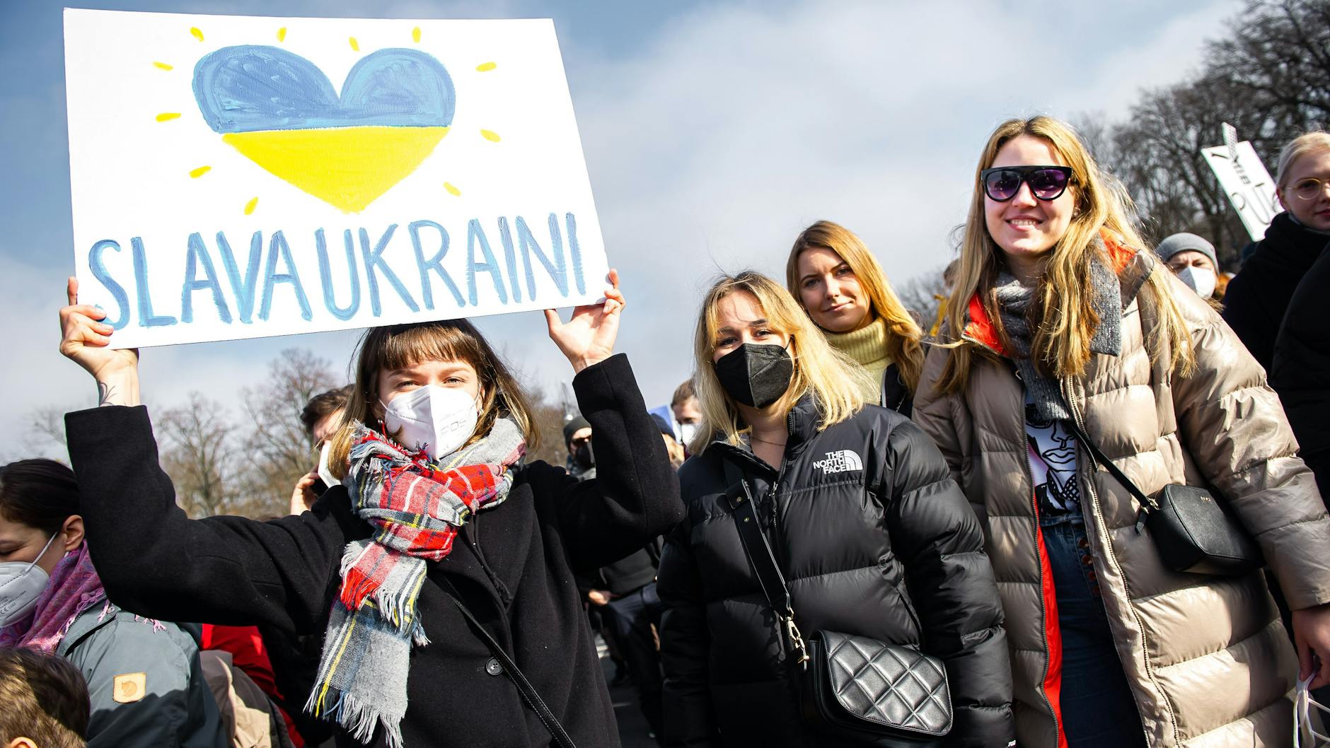 Litauerinnen auf der Demo: Eine hält ein Plakat "Ehre der Ukraine" hoch