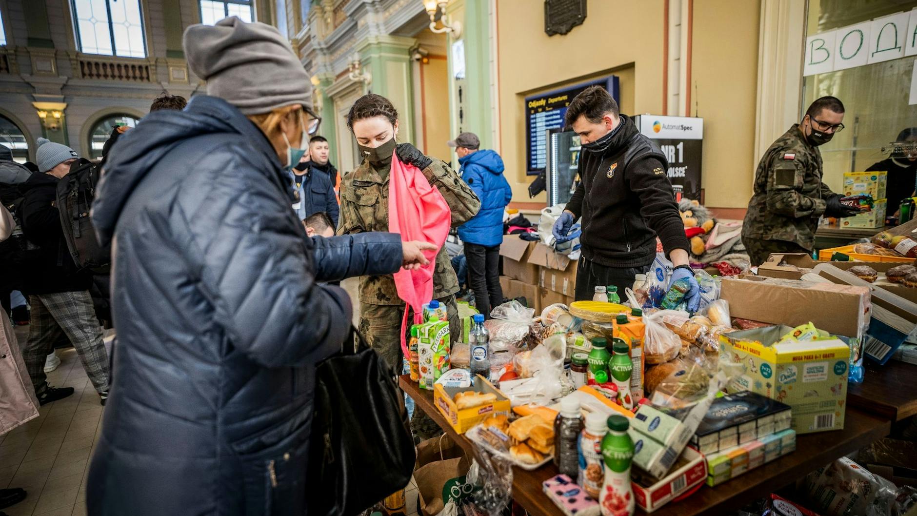 Helfer verteilen Lebensmittel und Süßigkeiten an Geflüchtete am Bahnhof von Przemysl.