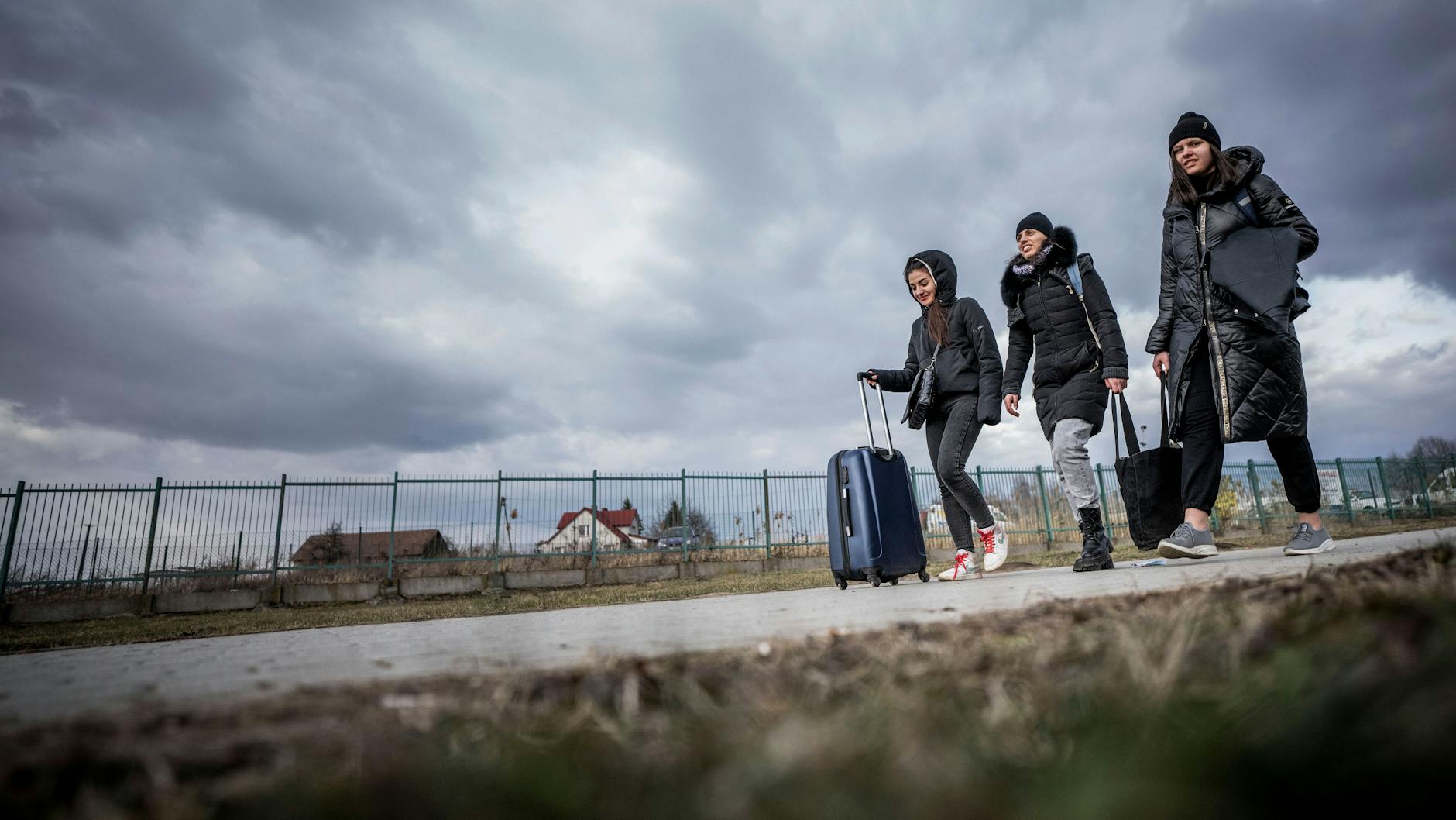 26.02.2022, Polen, Przemysl: Geflüchtete aus der Ukraine gehen nach ihrem Grenzübertritt in Polen durch das polnische Grenzgebiet. Zahlreiche Menschen verlassen nach dem Angriff Russlands auf die Ukraine das Land. Viele flüchten nach Polen.