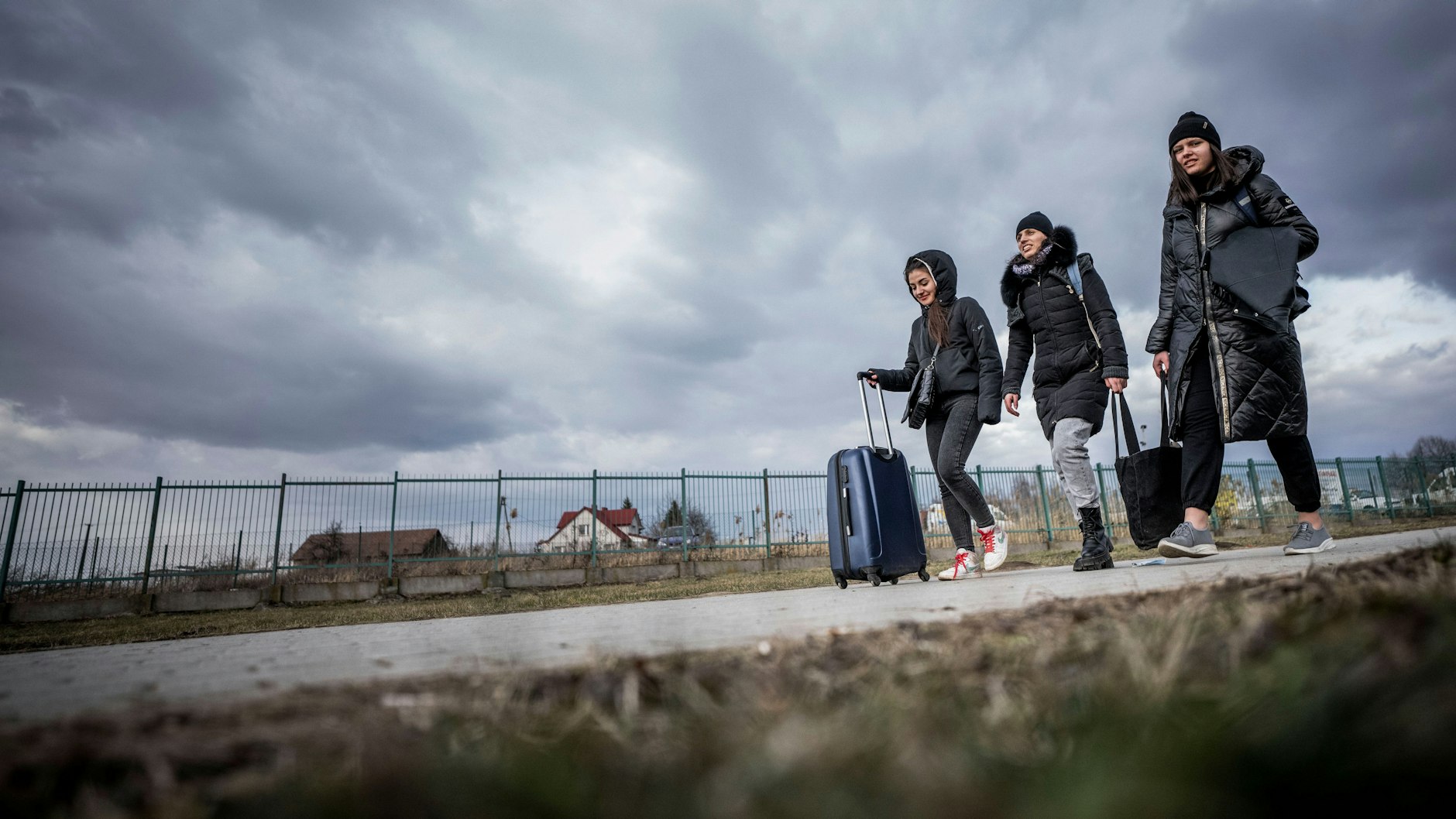 26.02.2022, Polen, Przemysl: Geflüchtete aus der Ukraine gehen nach ihrem Grenzübertritt in Polen durch das polnische Grenzgebiet. Zahlreiche Menschen verlassen nach dem Angriff Russlands auf die Ukraine das Land. Viele flüchten nach Polen.