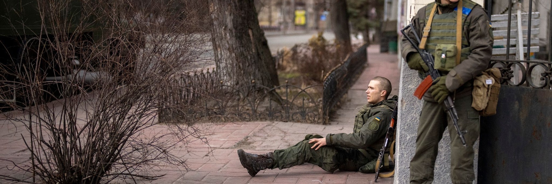 Ein ukrainischer Soldat sitzt nach einem Feuergefecht in Kiew verletzt auf dem Boden. 