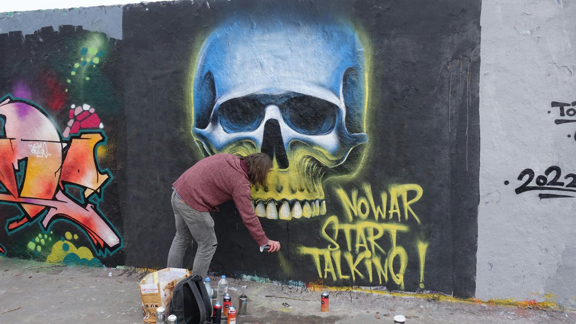 Der Berliner Streetartkünstler Suga_Art_Bln malte im Mauerpark das Bild „No war, start talking“.