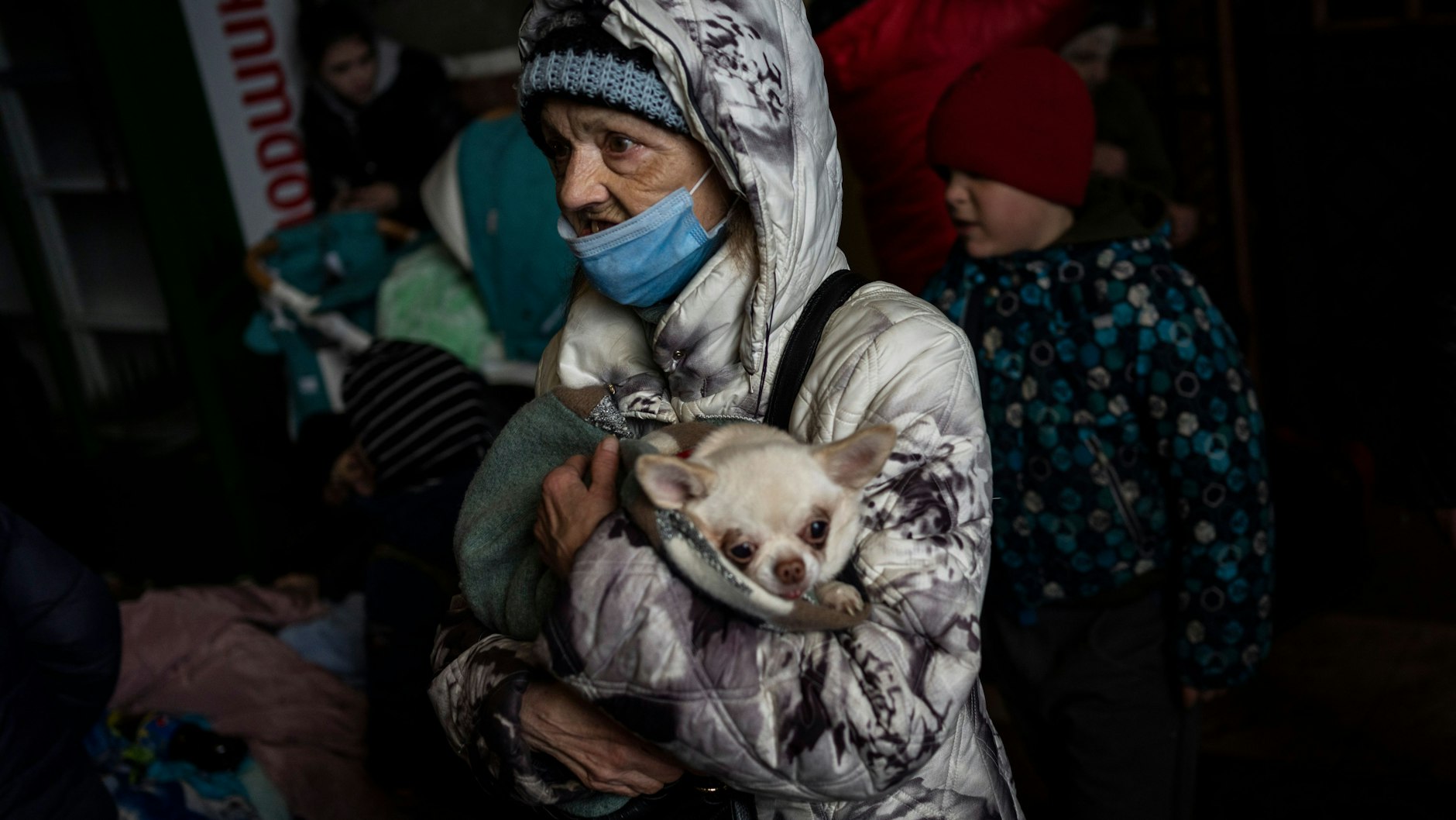 Eine ältere Frau und ihr Haustier warten im Bahnhof in Lwiw.