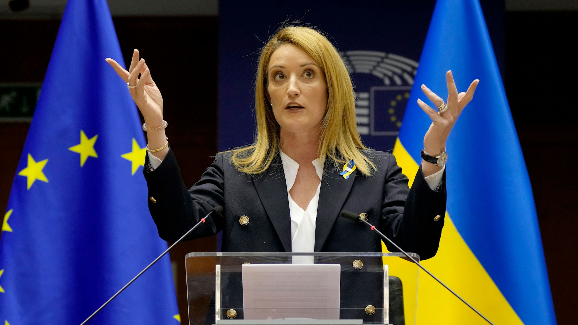 EU-Parlamentspräsidentin Roberta Metsola vor den Fahnen Europas und der Ukraine. Farblich passen die schon mal