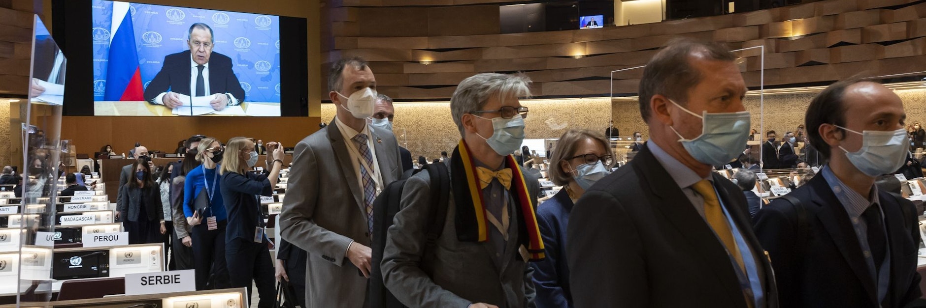 Botschafter und Diplomaten verlassen den Saal, während Sergej Lawrow (auf dem Bildschirm), Außenminister von Russland, mit einer aufgezeichneten Videobotschaft zur 49. Sitzung des UN-Menschenrechtsrats am europäischen Hauptsitz der Vereinten Nationen spricht.