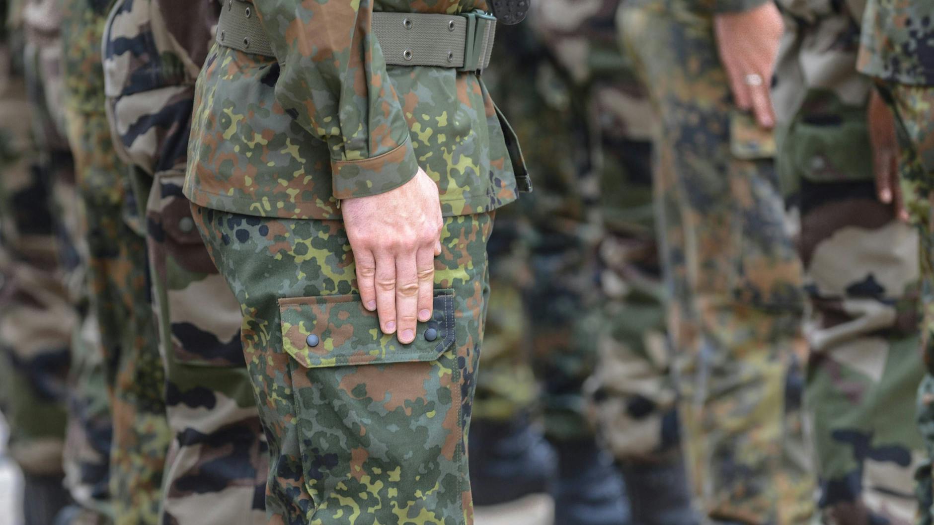 Soldaten der Deutsch-Französischen Brigade präsentieren das Gewehr bei einem Appell im südbadischen Müllheim.