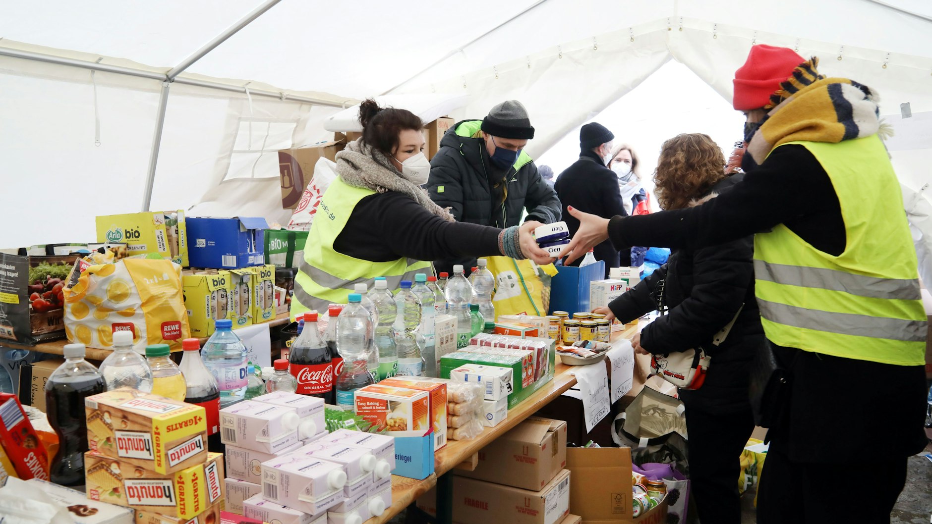 Helfer versorgen die ankommenden Flüchtlinge am Zentralen Omnibusbahnhof mit Lebensmitteln, Kleidung und Hygieneartikeln.
