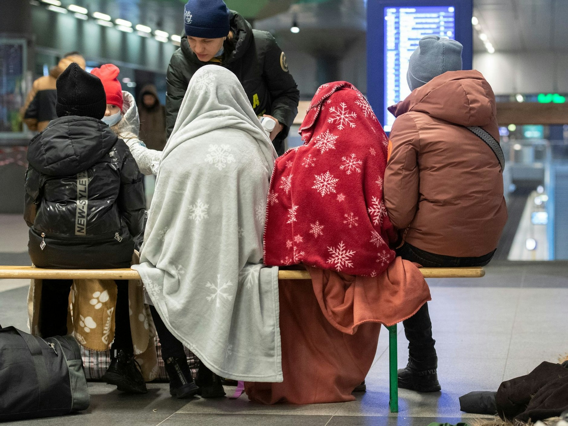 In Decken gehüllt sitzen diese Kinder aus dem ukrainischen Kriegsgebiet im Berliner Hauptbahnhof.
