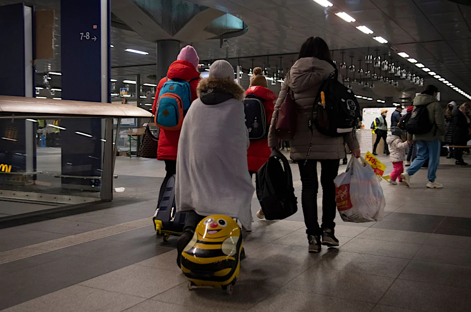 Flüchtlinge aus dem ukrainischen Kriegsgebiet gehen im Berliner Hauptbahnhof zu einer Sammelstelle.