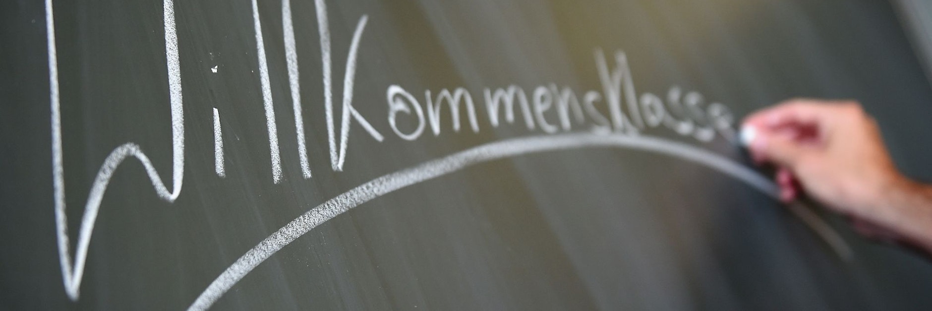 Ein Lehrer schreibt das Wort «Willkommensklasse» an die Tafel. Berlin hat gute Erfahrungen mit Willkommensklassen gemacht. Nun soll es sie auch für ukrainische Flüchtlinge geben.