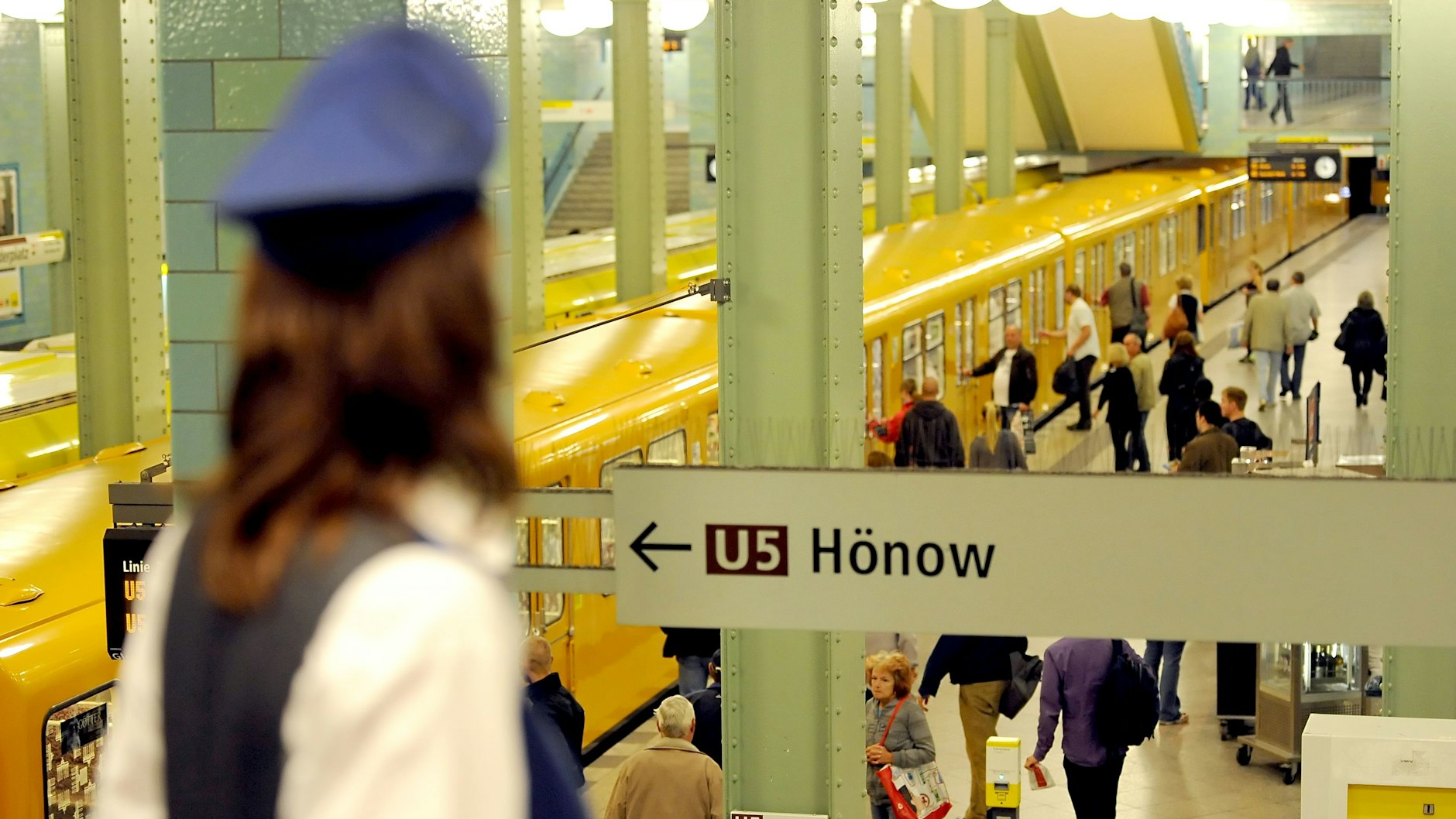 Eine Mitarbeiterin der BVG steht auf dem U-Bahnhof Alexanderplatz in Berlin.