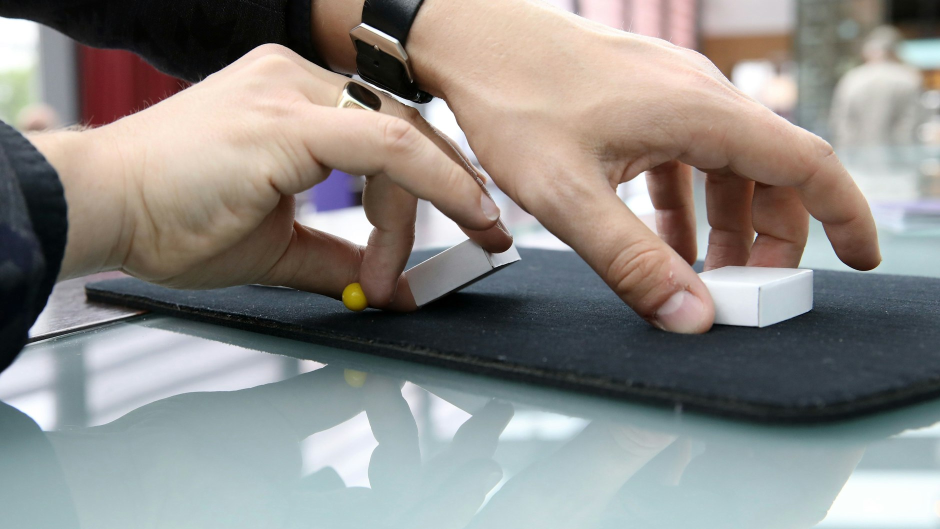 Dann heißt es, die Schachteln zu mischen. Der Spieler versteckt das kleine Kügelchen dabei zwischen den Fingern – die Zuschauer können es auch beim Mischen der drei Schächtelchen nicht sehen.