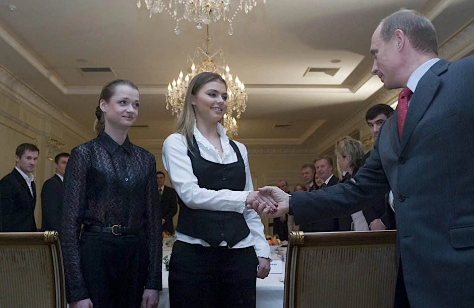 Russlands Präsident Wladimir Putin begrüßt bei einem Empfang die Turnerin Alina Kabajewa (M.).