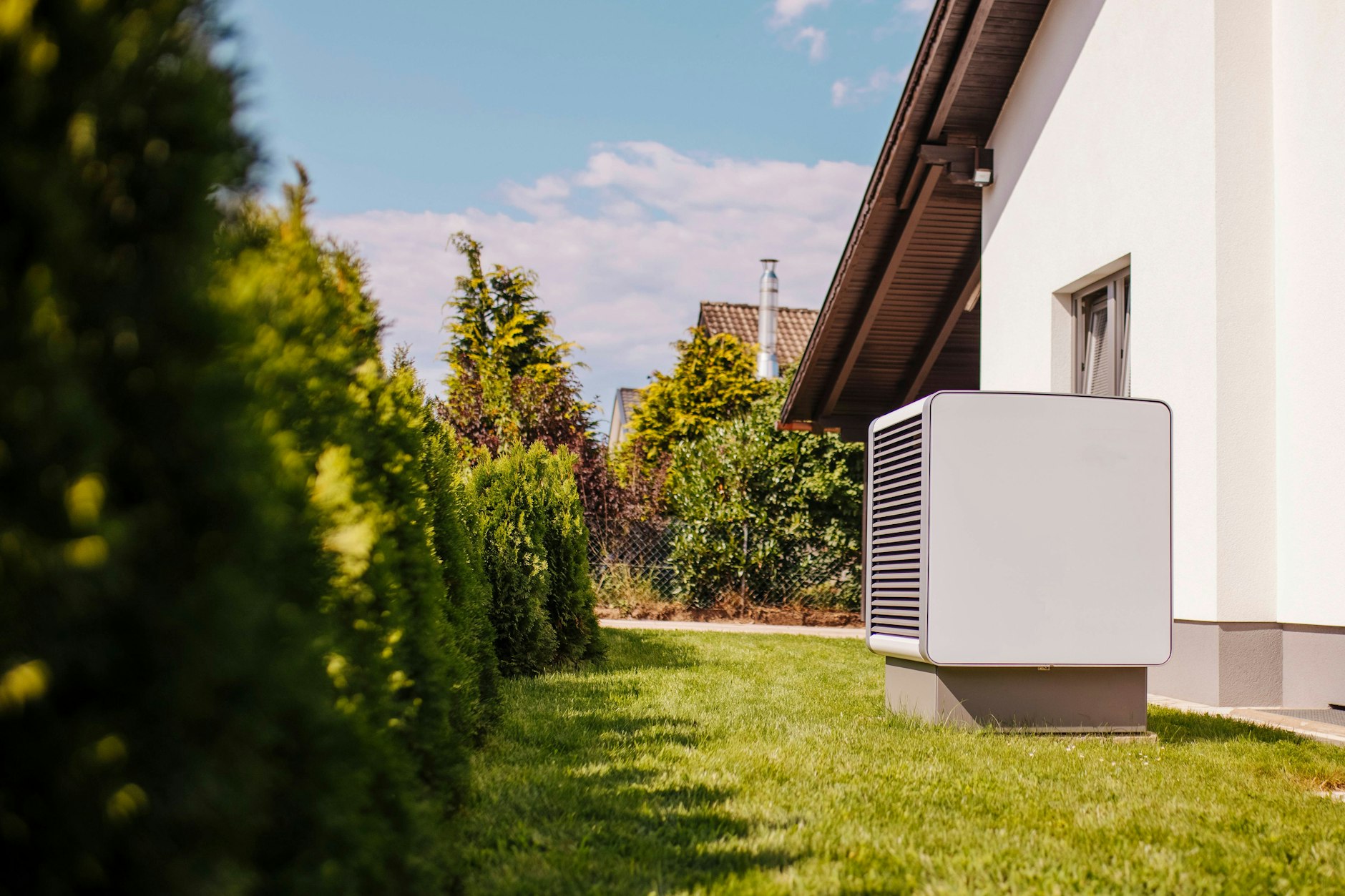 Eine Luftwärmepumpe vor einem Wohnhaus. Es gibt auch unterirdische Varianten: Erd- oder Grundwasserwärmepumpen.