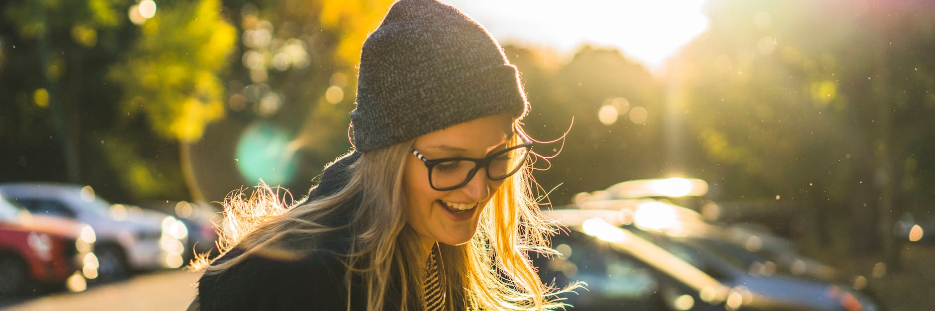 Eine junge Frau lacht in der Sonne.