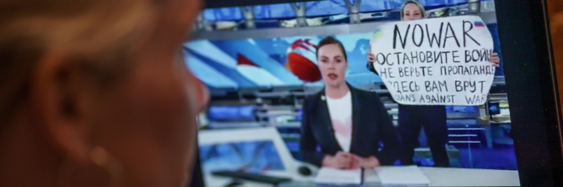 Mit einem Protestplakat und lauten Rufen hat eine Kriegsgegnerin im russischen Staatsfernsehen für eine Unterbrechung der Hauptnachrichtensendung gesorgt.