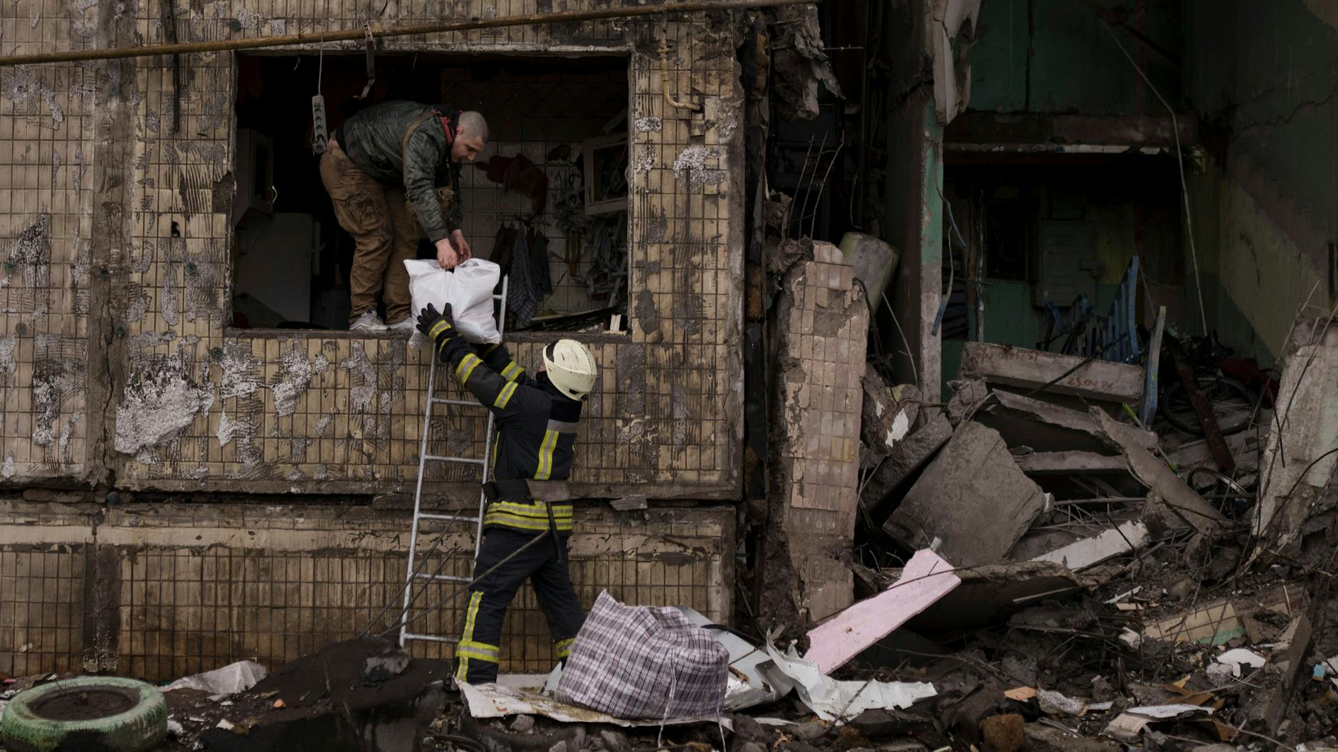 Ein Mann rettet sich aus einem zerstörten Gebäude in Kiew. Er hat andere Sorgen, als Bücher zu lesen.