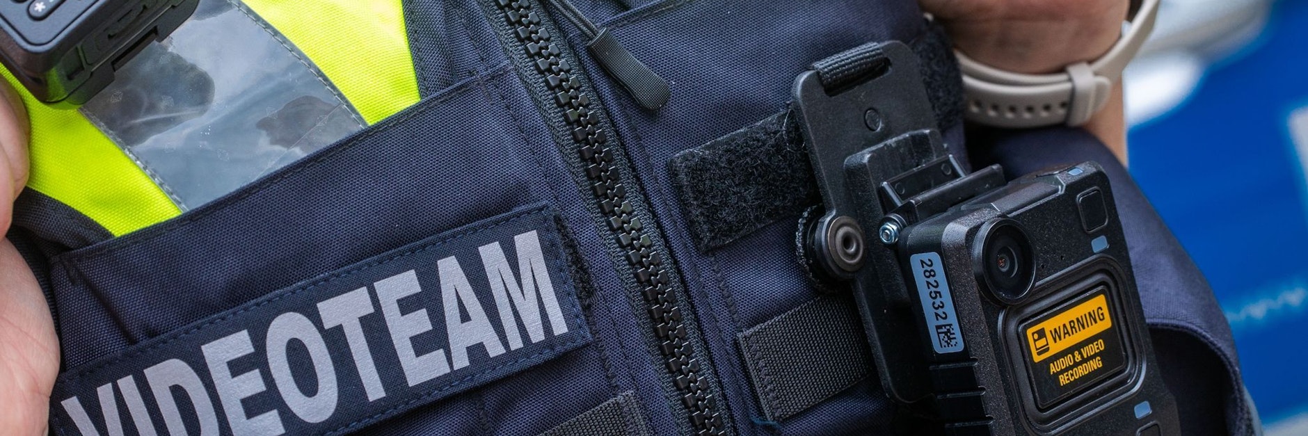 Eine Body-Cam hängt an der Schutzweste einer Polizeibeamtin.