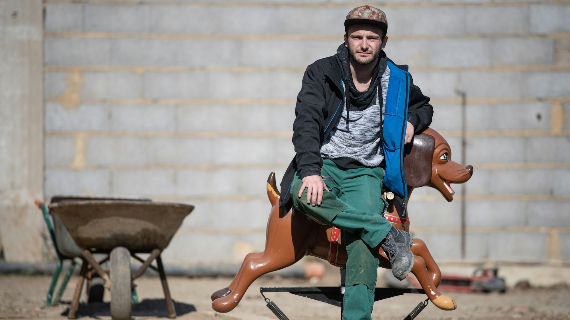 Der Schausteller Tim Himmes sitzt inmitten seiner Haus-Baustelle auf einem alten Karusselltier. 