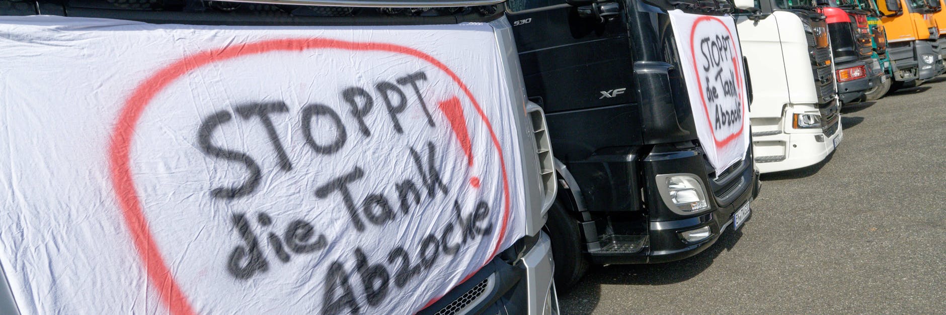 Auf einer LKW Zugmaschine ist bei einer Lkw-Demonstration gegen hohe Kraftstoffpreise ein Schild mit der Aufschrift "Stoppt die Tankabzocke" angebracht. In Berlin und wie hier in NRW wollen Fuhrunternehmen protestieren.