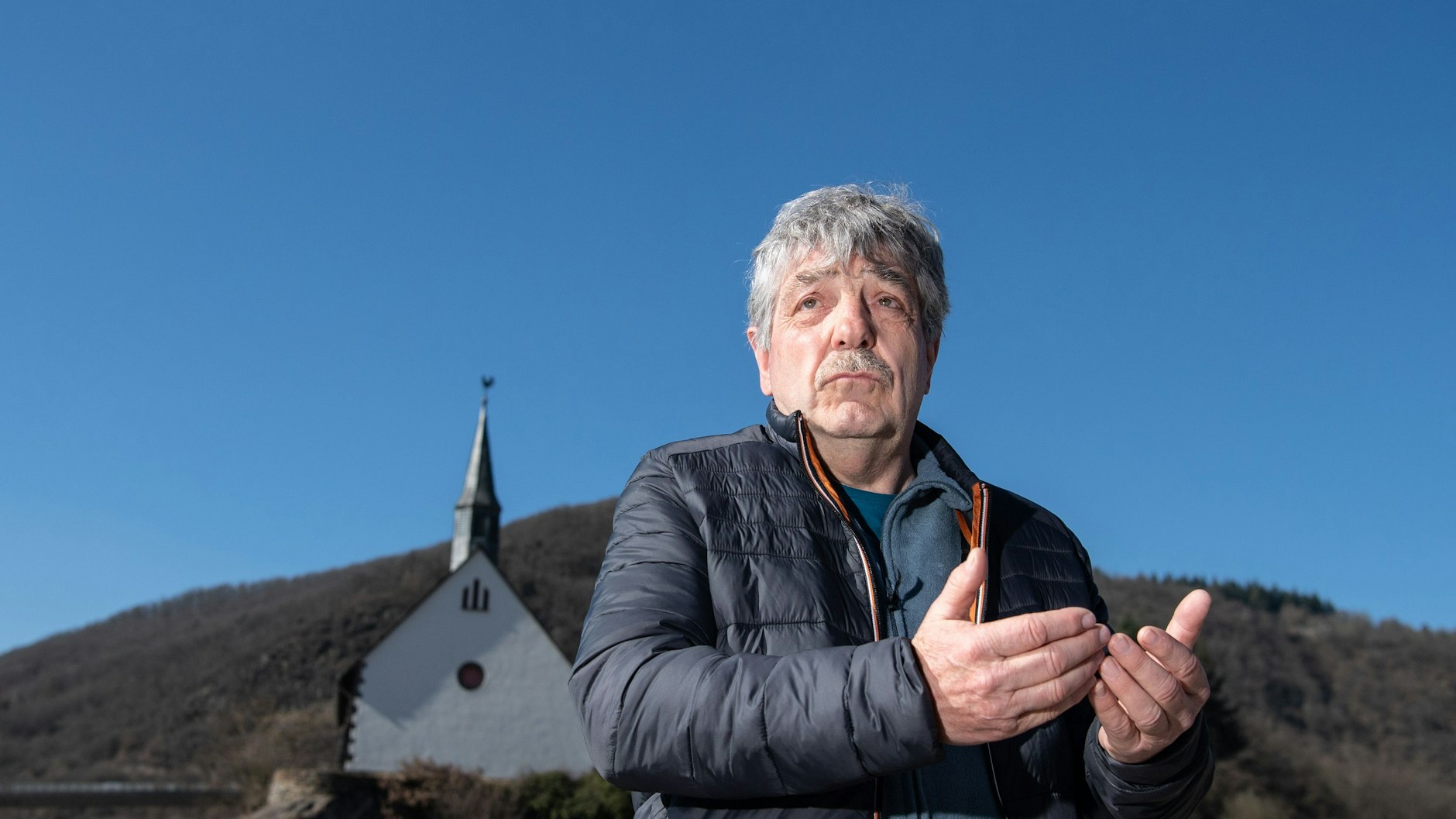 Bernd Gasper steht am Ufer der Ahr. Sein Elternhaus, das an dieser Stelle gestanden hatte, wurde mittlerweile abgerissen.
