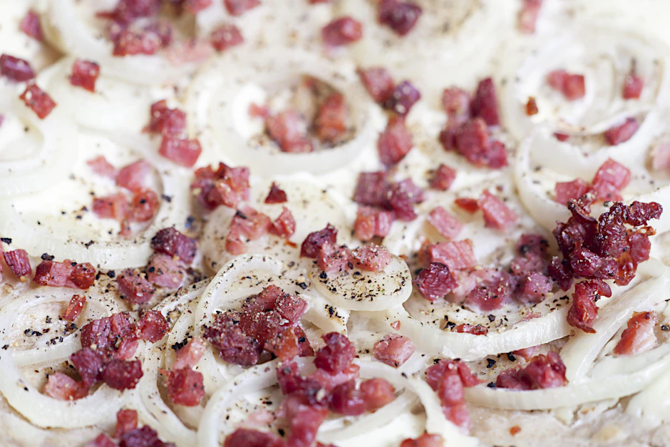 Mit Zwiebeln und Schinkenwürfeln wird der Flammkuchen perfekt. Mit dem Blumenkohlboden wird das Gericht zur leichten Alternative fürs Abendessen.