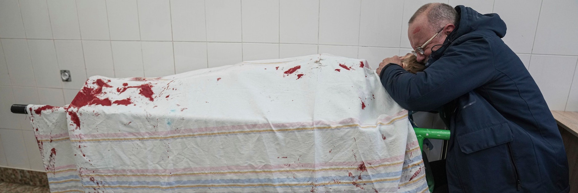 Vater Serhii weint vor dem bedeckten Leichnam seines Sohnes Iliya, der bei russischem Beschuss eines Kinderkrankenhauses getötet wurde.