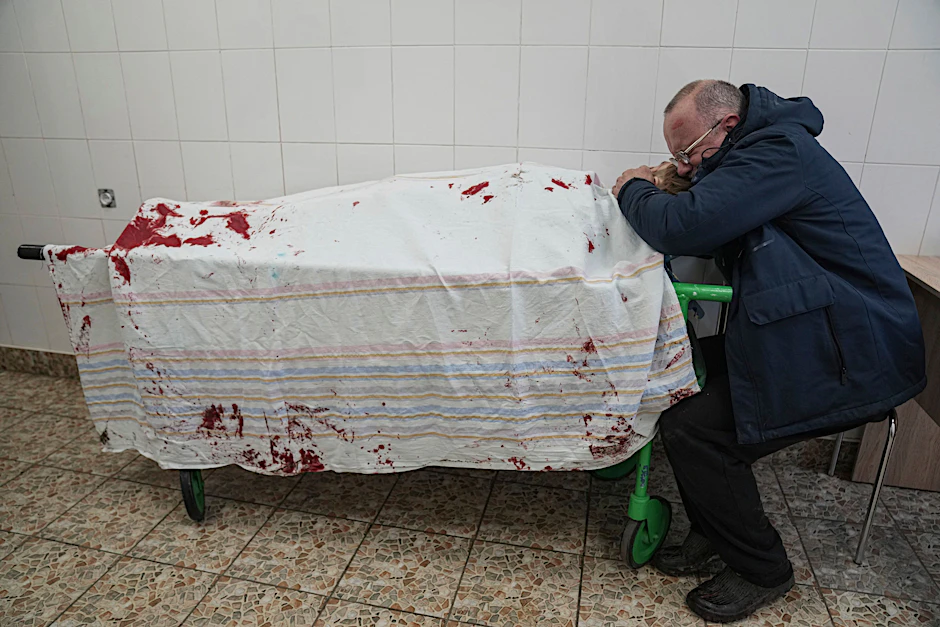 Vater Serhii weint vor dem bedeckten Leichnam seines Sohnes Iliya, der bei russischem Beschuss eines Kinderkrankenhauses getötet wurde.