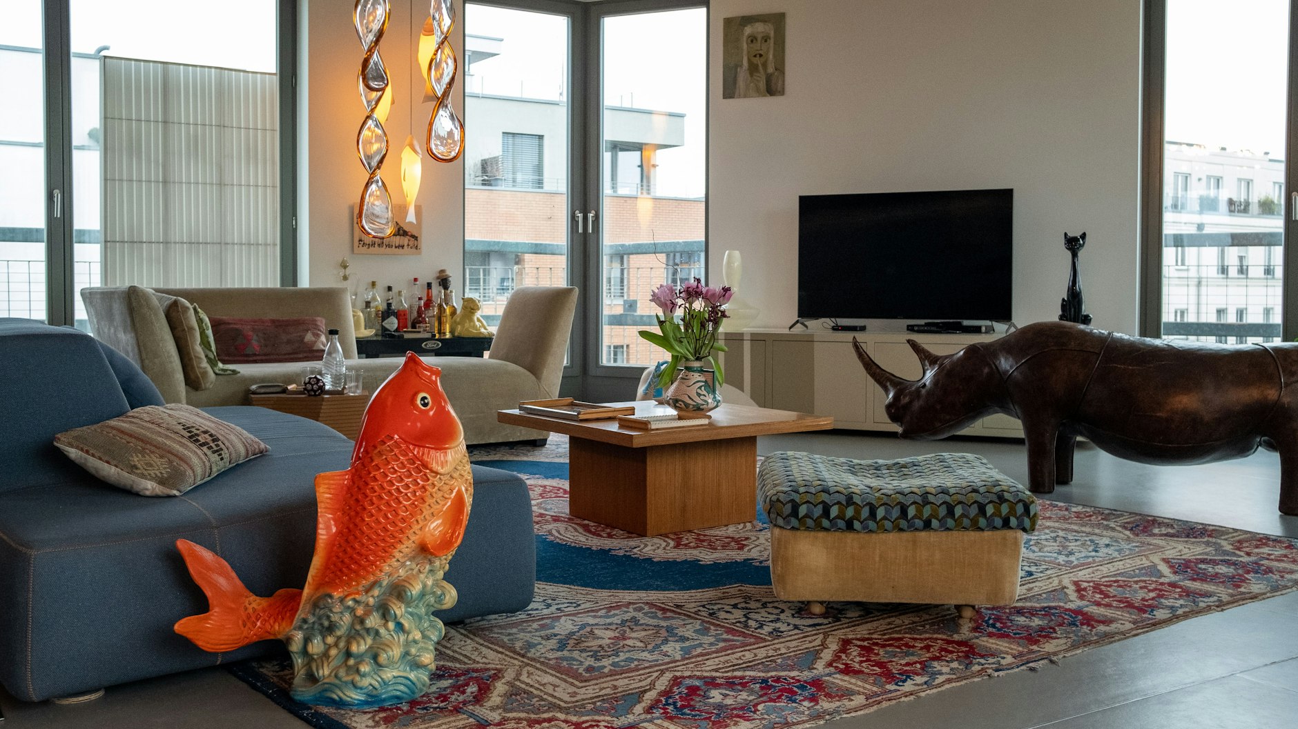 Privatzoo: Das Wohnzimmer mit einem Glücksbringer aus Gips in Fischform aus New Yorks Chinatown und der Leder-Sitzbank „Rhinoceros“ aus den 70ern von Dimitri Omersa. Das Glas-Windspiel ist aus Murano.