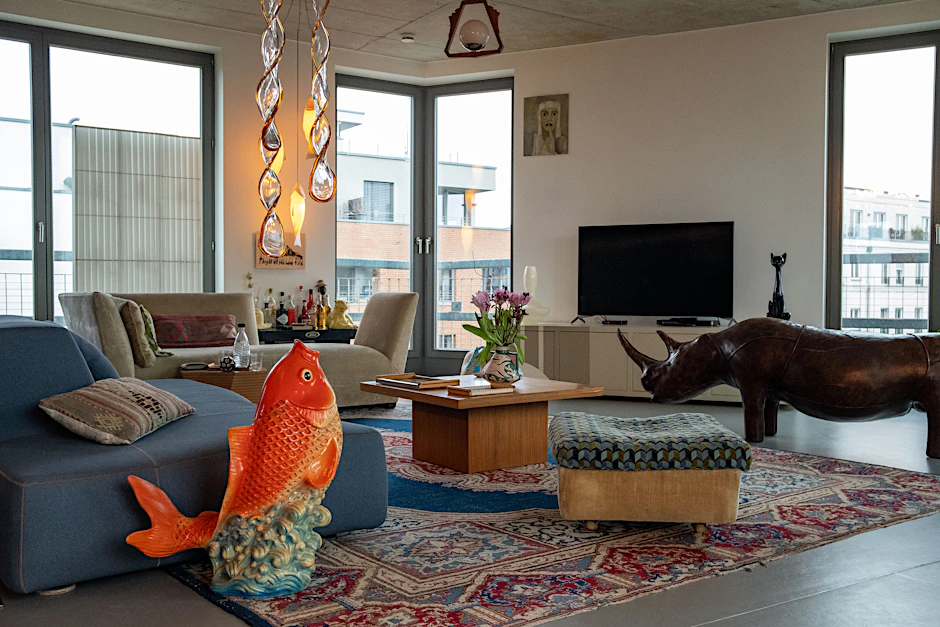 Privatzoo: Das Wohnzimmer mit einem Glücksbringer aus Gips in Fischform aus New Yorks Chinatown und der Leder-Sitzbank „Rhinoceros“ aus den 70ern von Dimitri Omersa. Das Glas-Windspiel ist aus Murano.