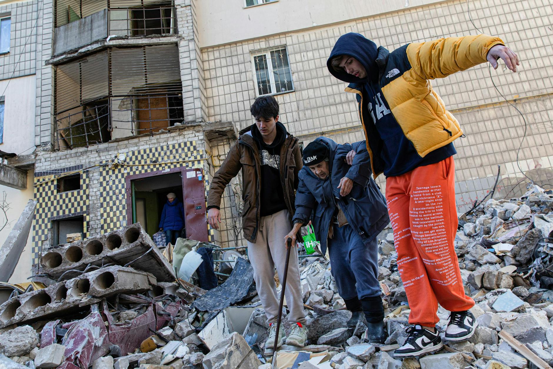 Kiew, 17. März: Zwei Männer helfen einer alten Frau über die Trümmer eines Wohngebäudes