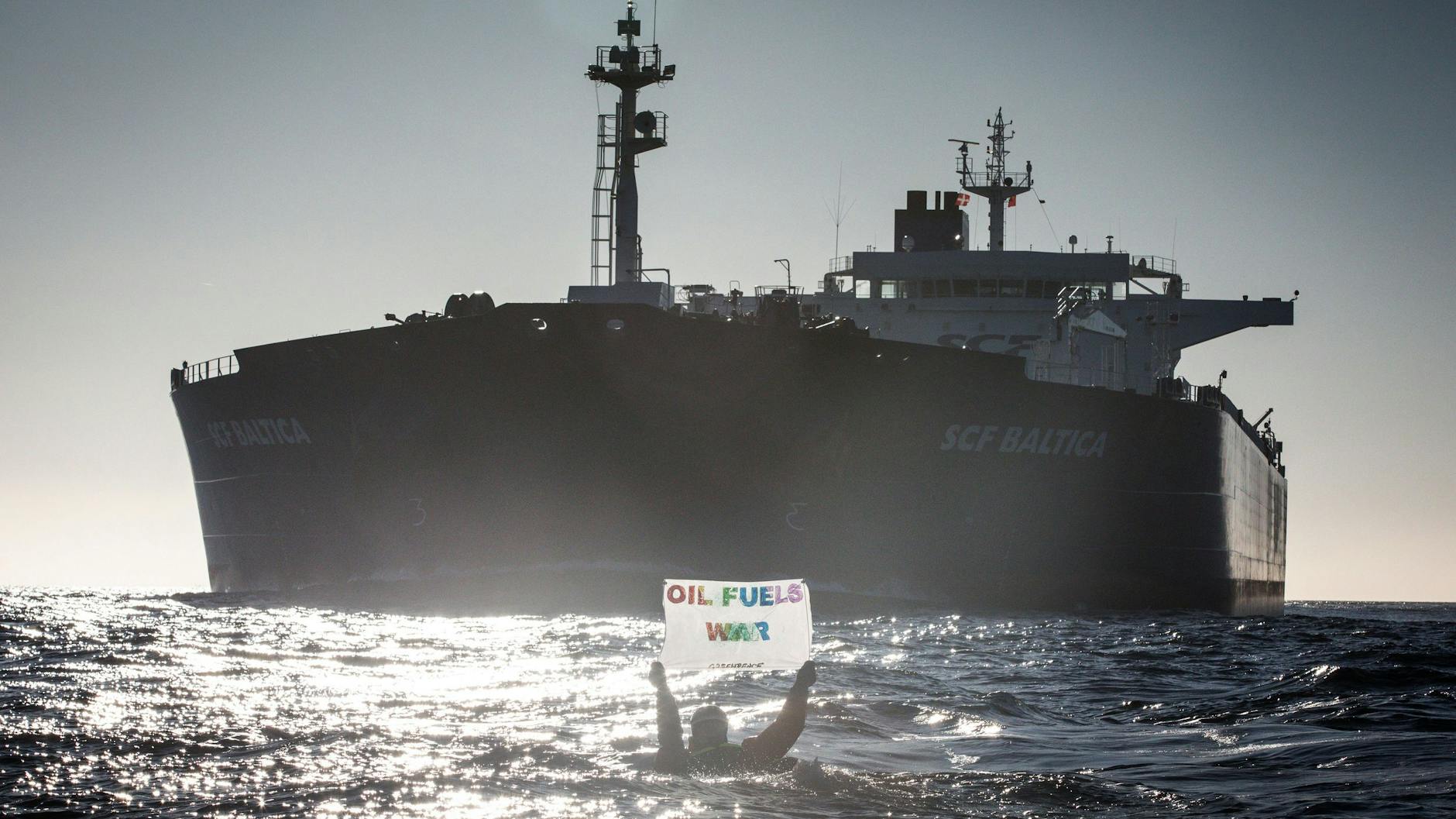 Ein Greenpeace-Aktivist protestiert in der Ostsee schwimmend gegen russische Ölimporte.