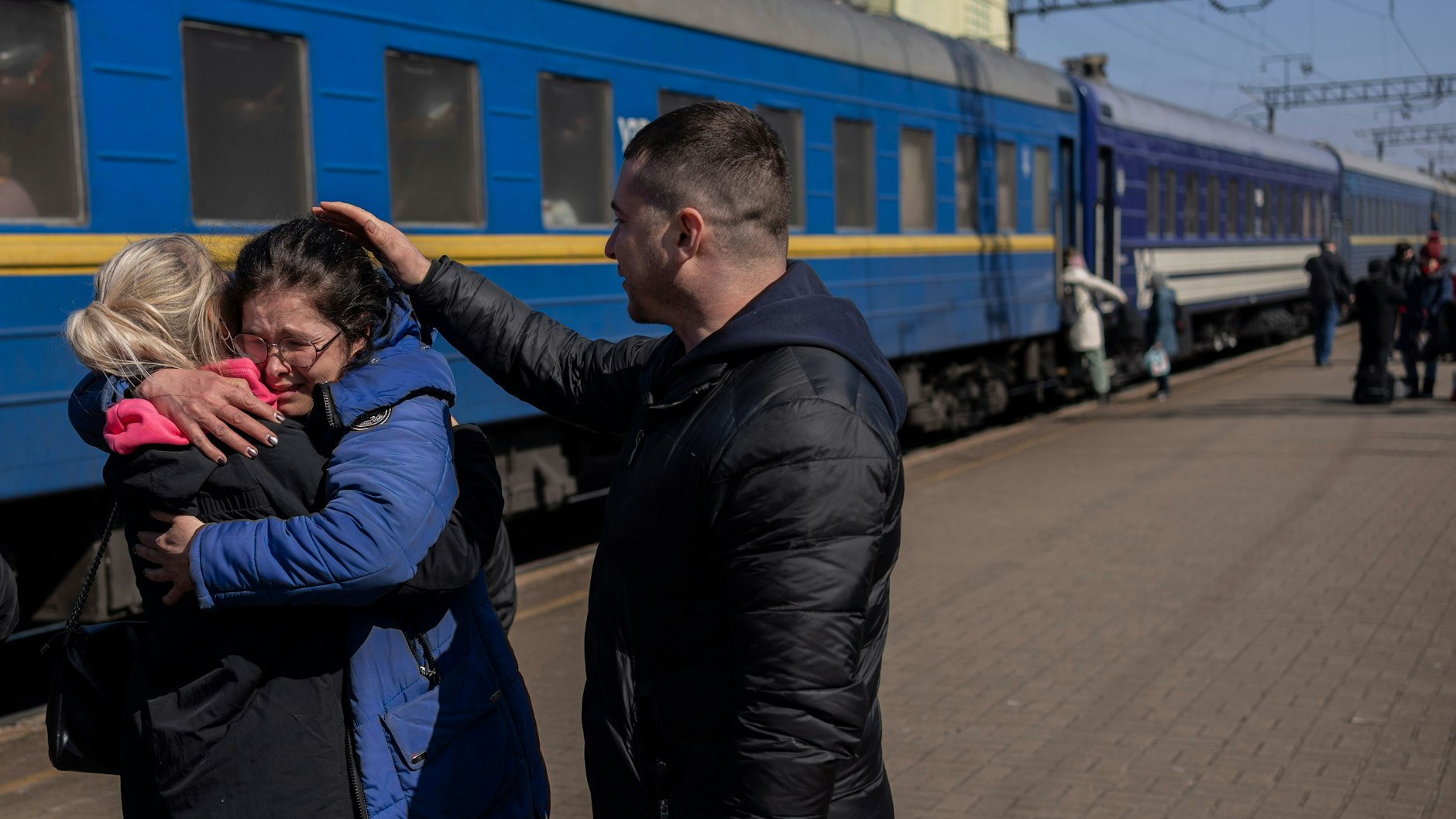 Olga Nikitina (M.) umarmt ihre Schwester, die sie auf dem Bahnhof von Lwiw in Empfang nahm. 