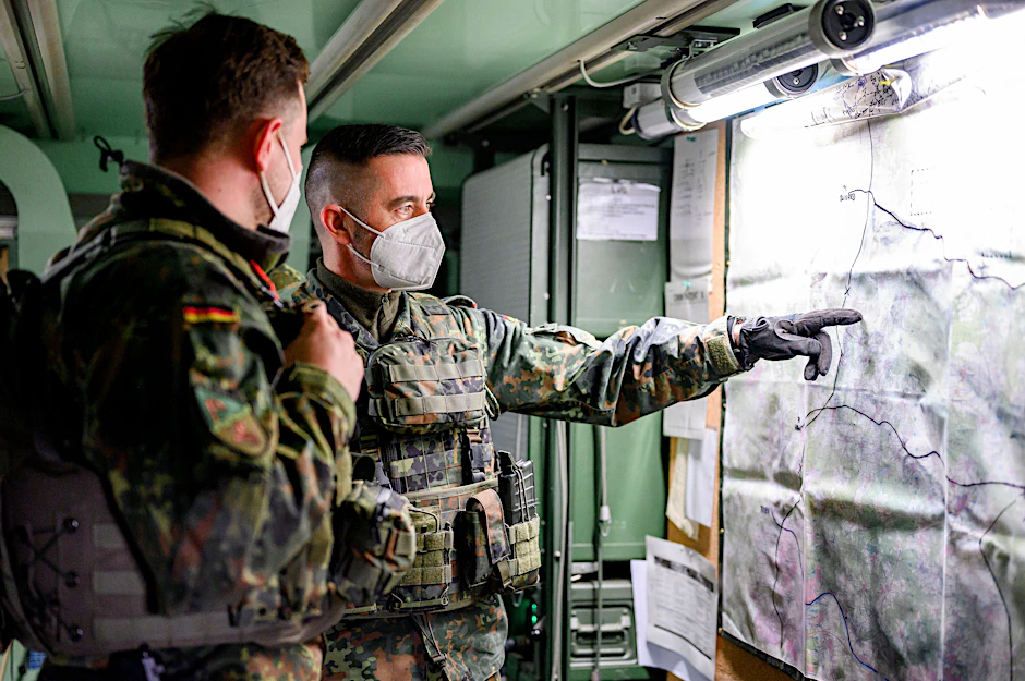 Zwei Soldaten sichten eine Karte im Rahmen einer Übung eines simulierten Gefechts am Computer für die Nato-Einsatzgruppe im Gefechtssimulationszentrum des Heeres in Wildflecken.