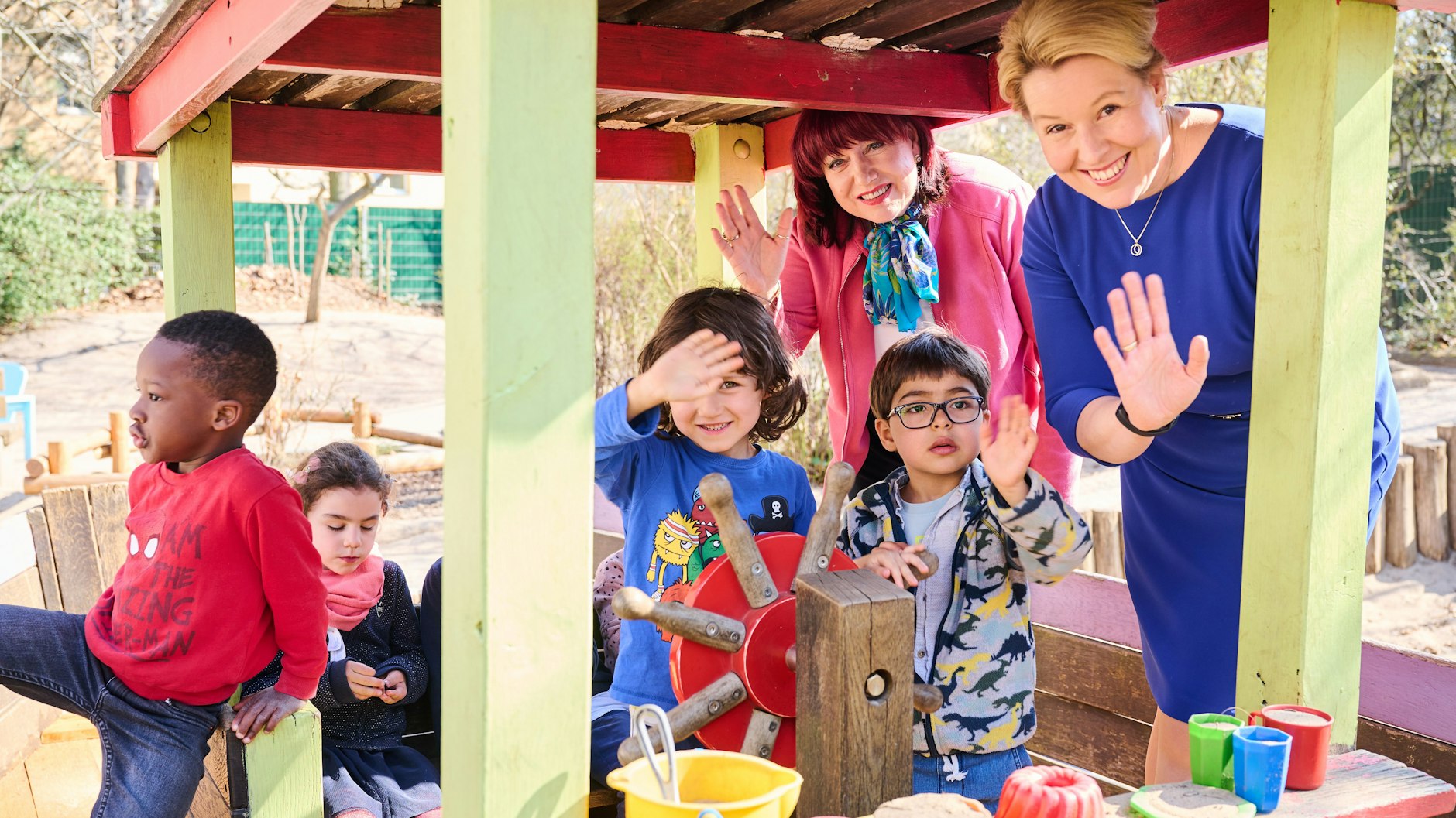Bildungssenatorin Astrid-Sabine Busse und Bürgermeisterin Franziska Giffey (r.) auf dem Außengelände der INA-Kindertagesstätte in Berlin-Schöneberg. Die Kinder (von links nach rechts) heißen Triomph, Leopoldine, Jona und Robin.
